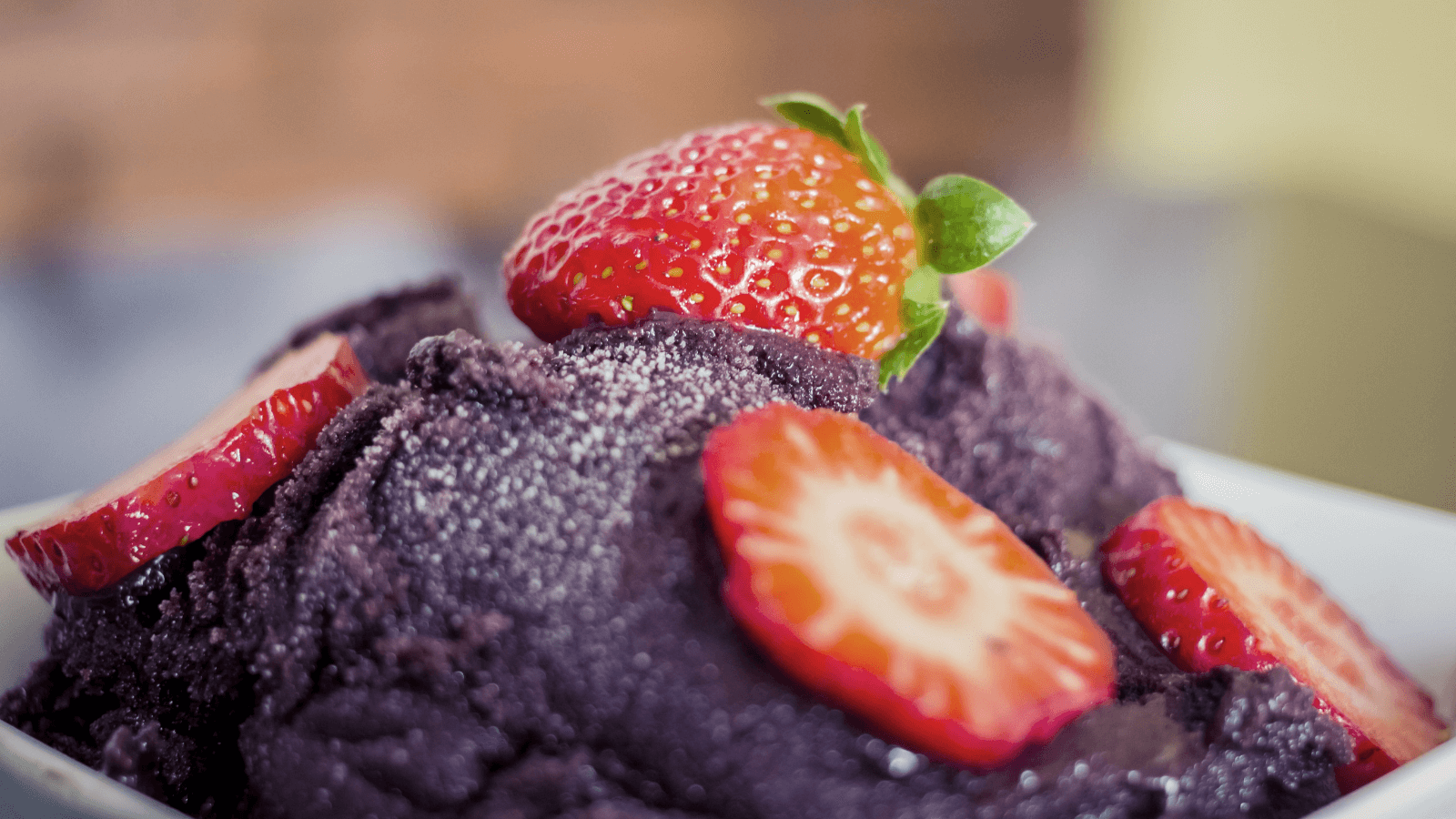 Close-up of acai smoothie bowl topped with fresh strawberry slices.